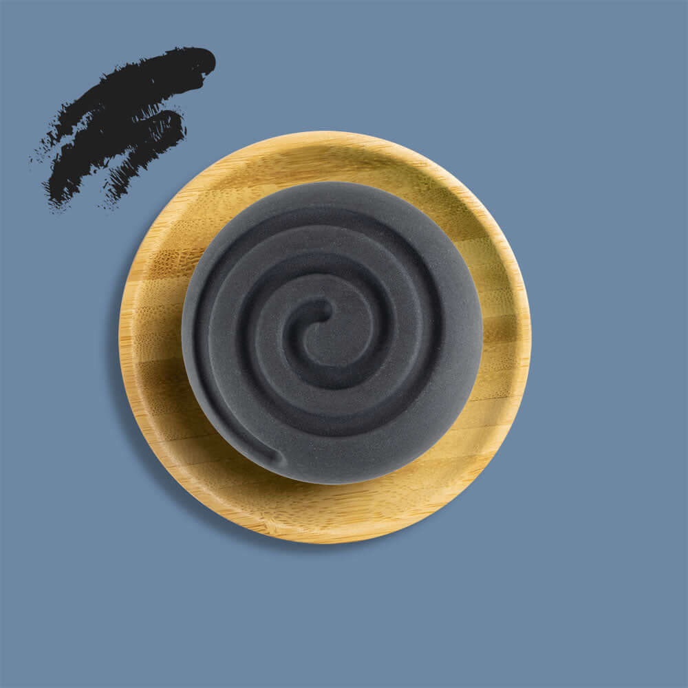 Festes Shampoo Naturkosmetik mit Aktivkohle auf Bambusablage