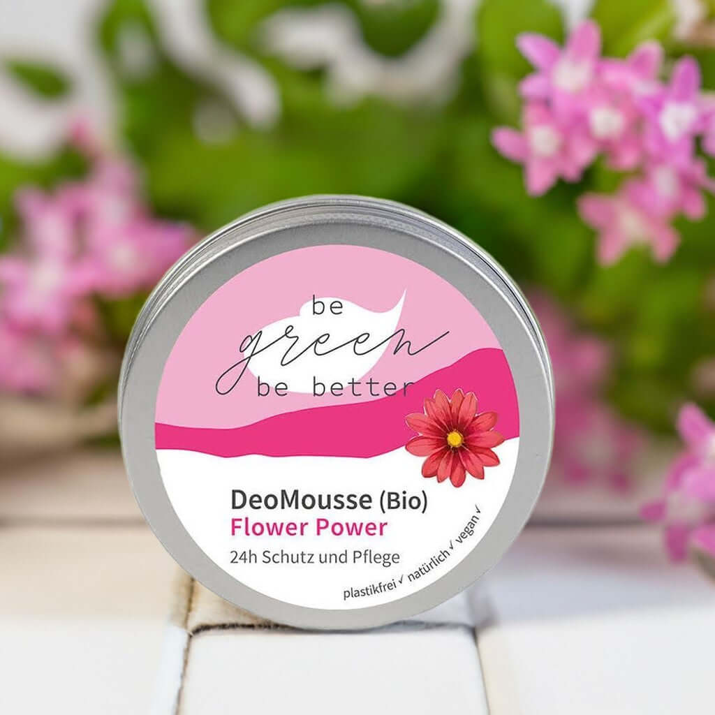 DeoMousse Flower Power Bio in elegantem Döschen mit blühendem Hintergrund für natürlichen Schutz und Pflege.