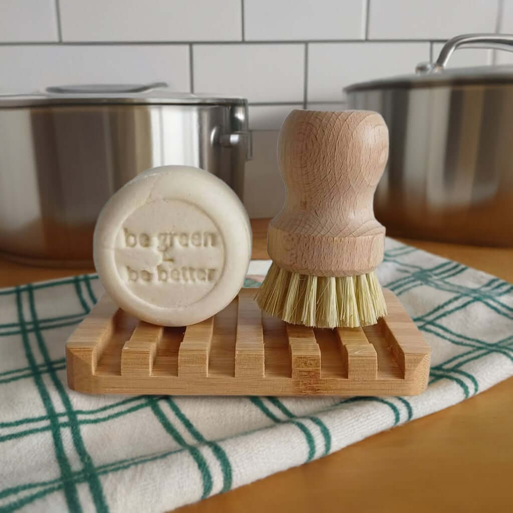 festes Spülmitter mit Bürste vor Töpfen